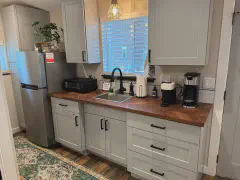 Kitchenette with walnut countertops and full-size fridge